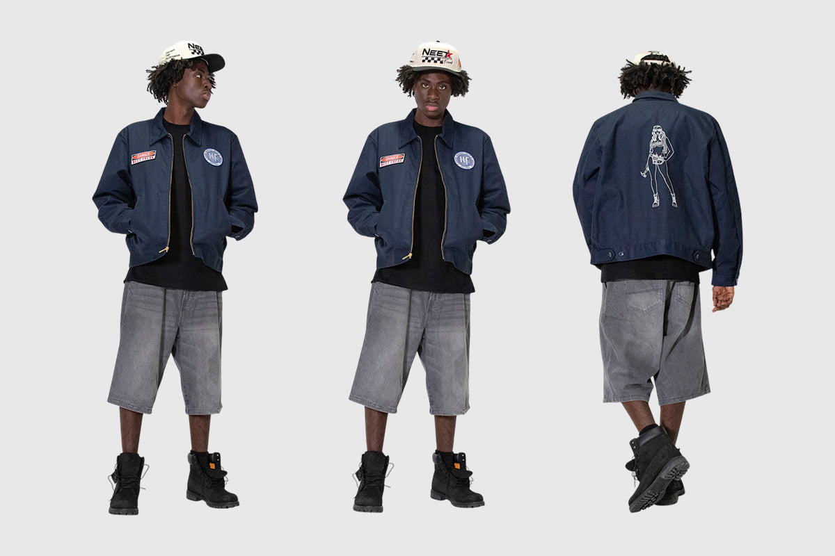 Model wearing Navy Blue Neet Freak work jacket with grey shorts Black tshirt and black timberland boots. Topped off with the High performance Neet Freak Hat