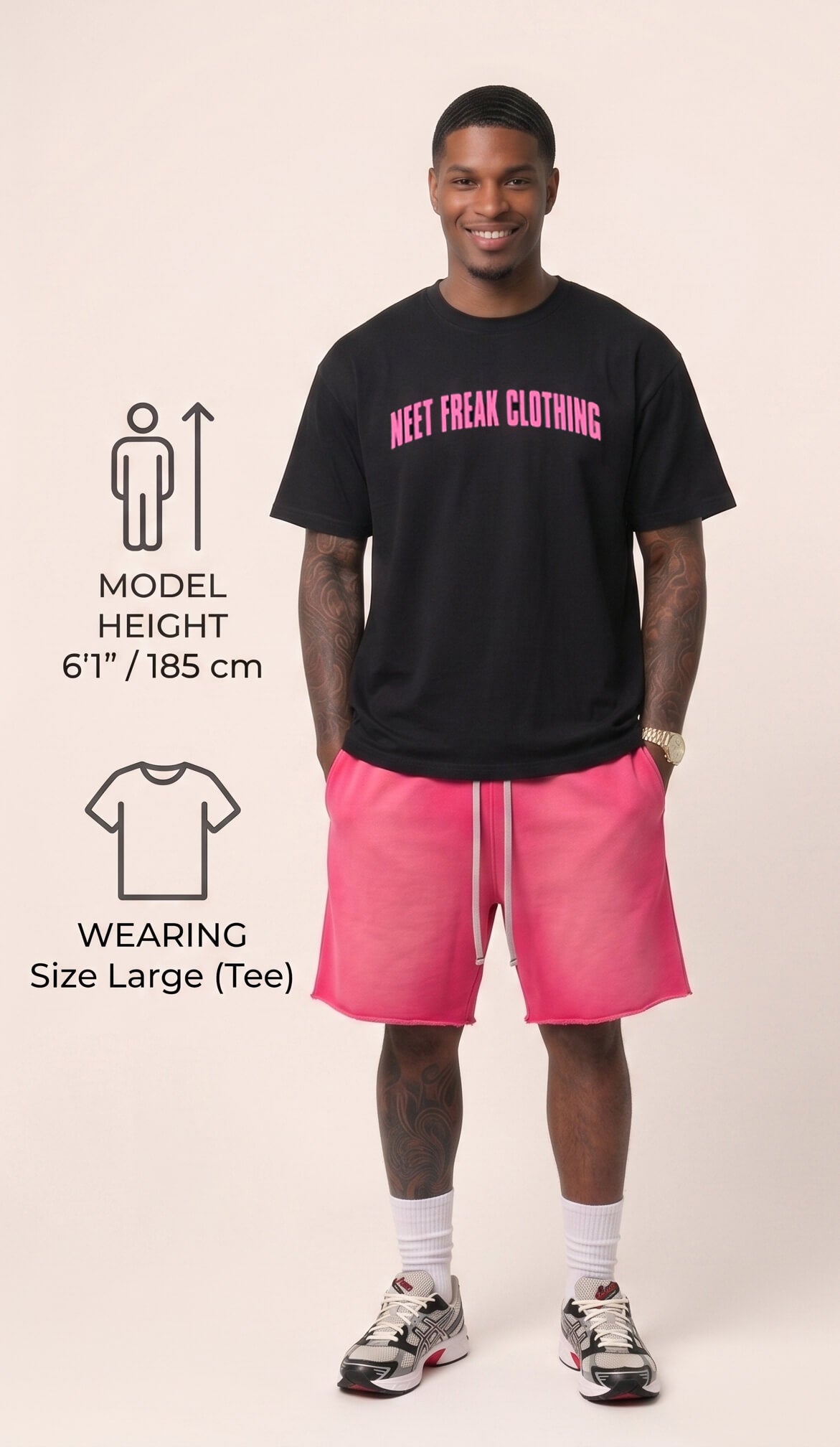 Man wearing a black t-shirt with pink text and pink shorts on a beige background