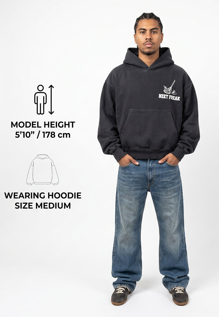 Man wearing a black hoodie with a logo, standing against a white background.