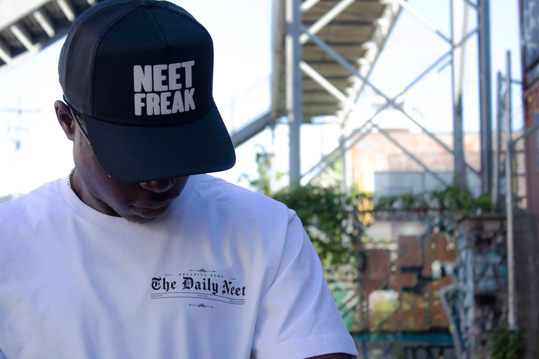 Model in the White Breaking News T-shirt and Black Mesh Trucker Hat.