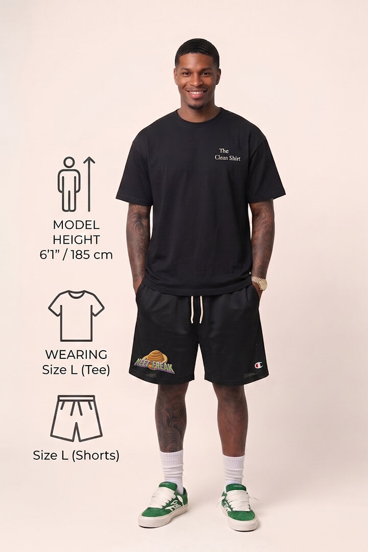 Man wearing a black t-shirt and shorts with branding, standing against a plain background.