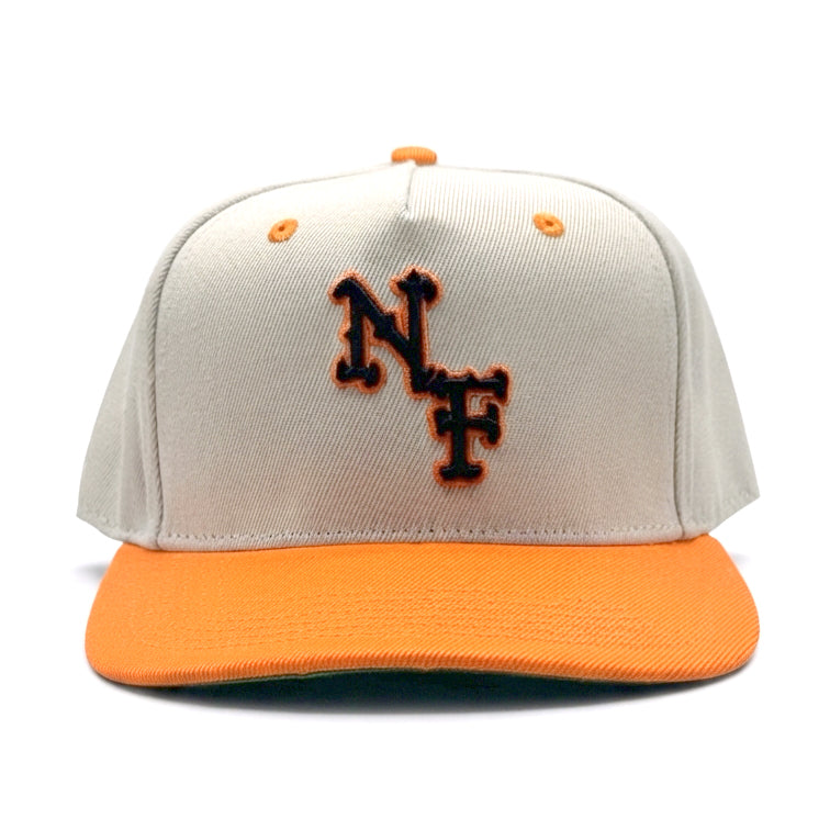 A structured baseball cap with an off-white crown and a bright orange flat brim. The front of the crown features an embroidered 'NF' logo in orange with a black outline. Inside is lined with satin to treat hear better. Also Has a Strap closer.