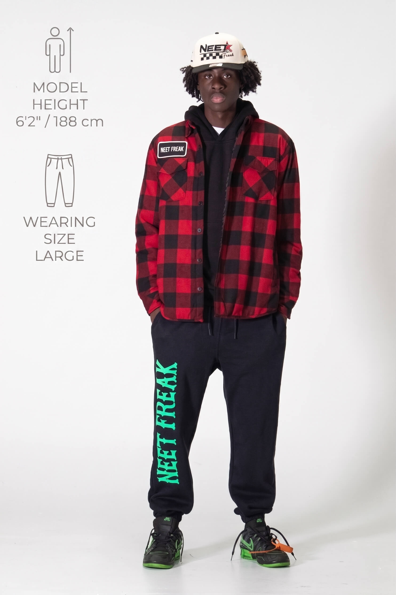 Person wearing a red plaid jacket and black pants with 'Neet Freak' text, standing against a white background.